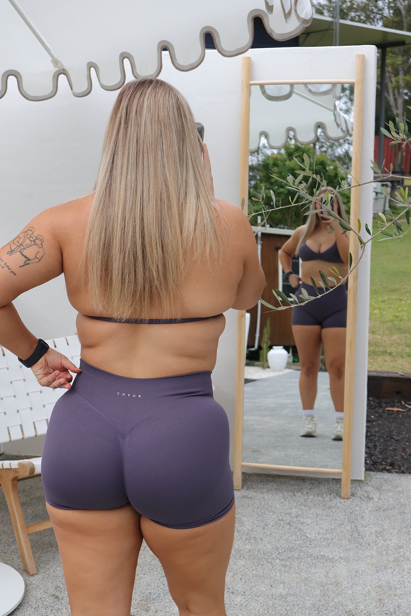 Woman wearing the Storm seamless activewear set from CNTOR the Label, standing confidently in front of a mirror showcasing the fit and design.