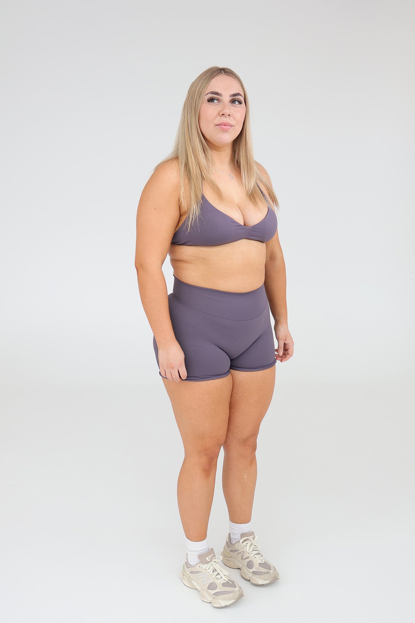 Woman wearing cntor sports bra and shorts set on a white background
